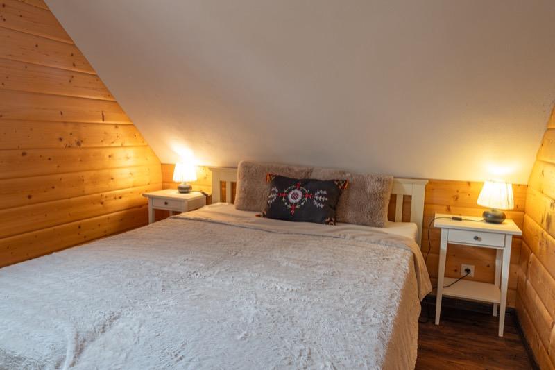 Bielo-šedá spálňa — detail postele